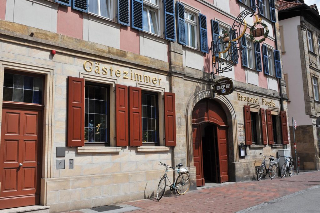 The Brauerei Fässla brewery and tavern facade on Obere Königstraße in Bamberg, with its wrought-iron hanging sign and shuttered windows.