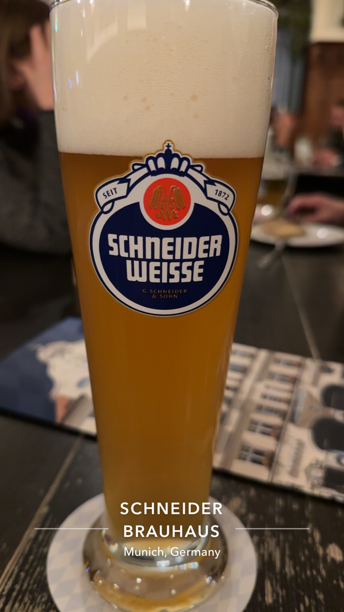 A tall glass of Schneider Weisse Original with a towering head, poured at the Schneider Bräuhaus.
