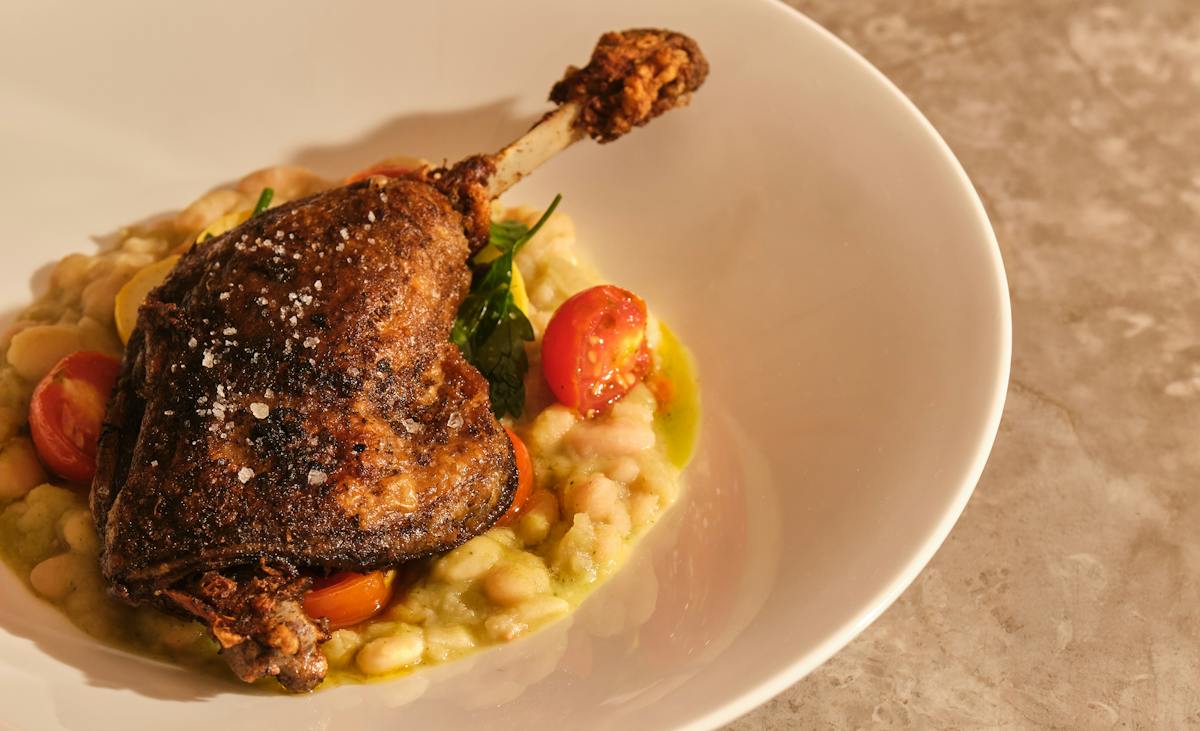 Duck confit over white beans with blistered tomatoes at Chemin a la Mer, New Orleans
