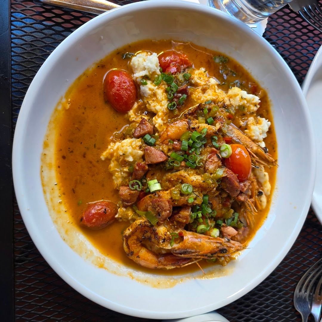 A plate of Atchafalaya's signature fried chicken and crab-topped dishes at the Uptown New Orleans restaurant, golden and crisp in close-up.