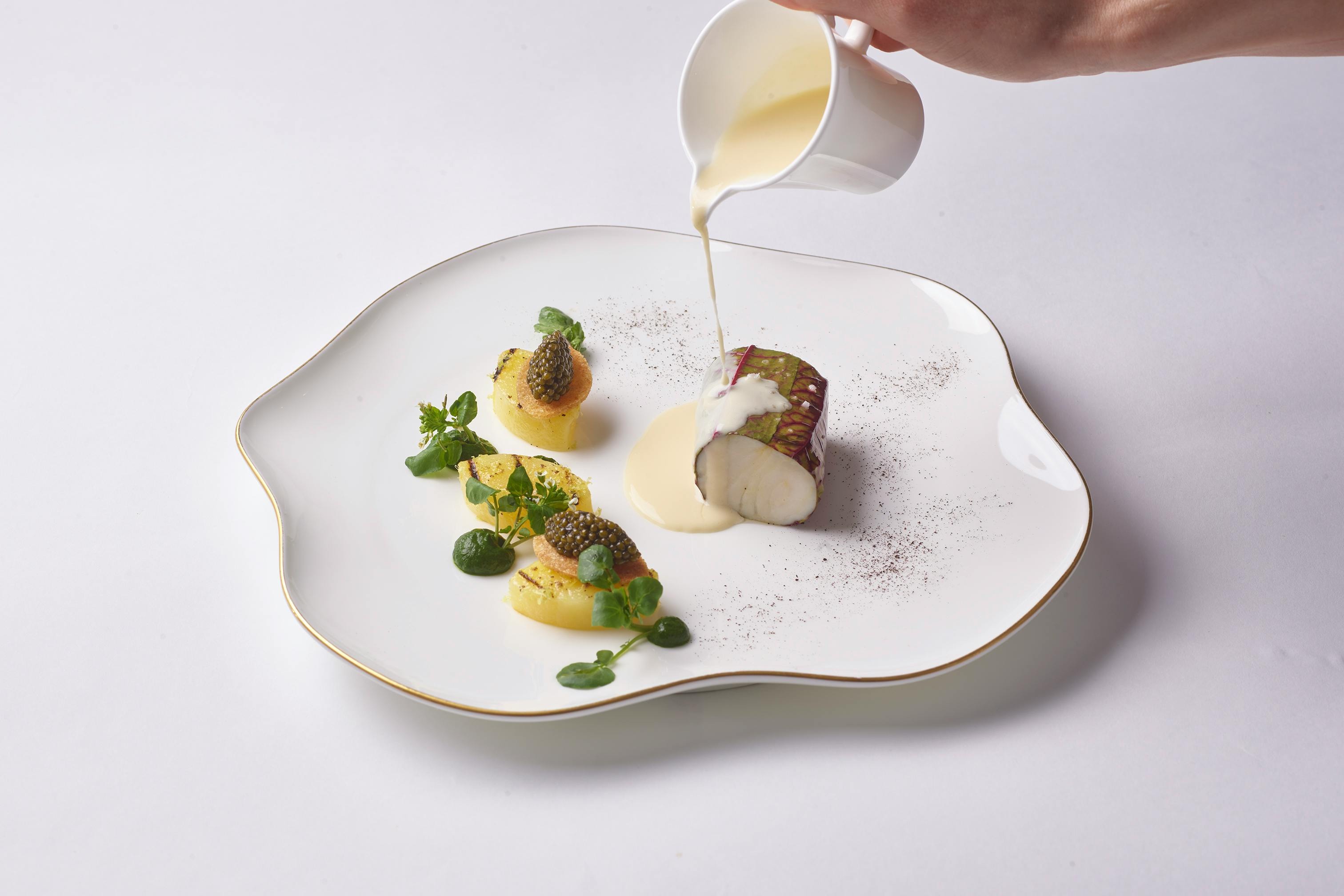 A signature fish course at Daniel, finished tableside