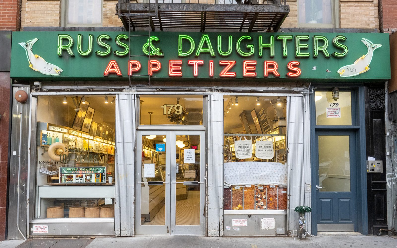Russ & Daughters Appetizers storefront at 179 E Houston St: green and red neon sign over the windows