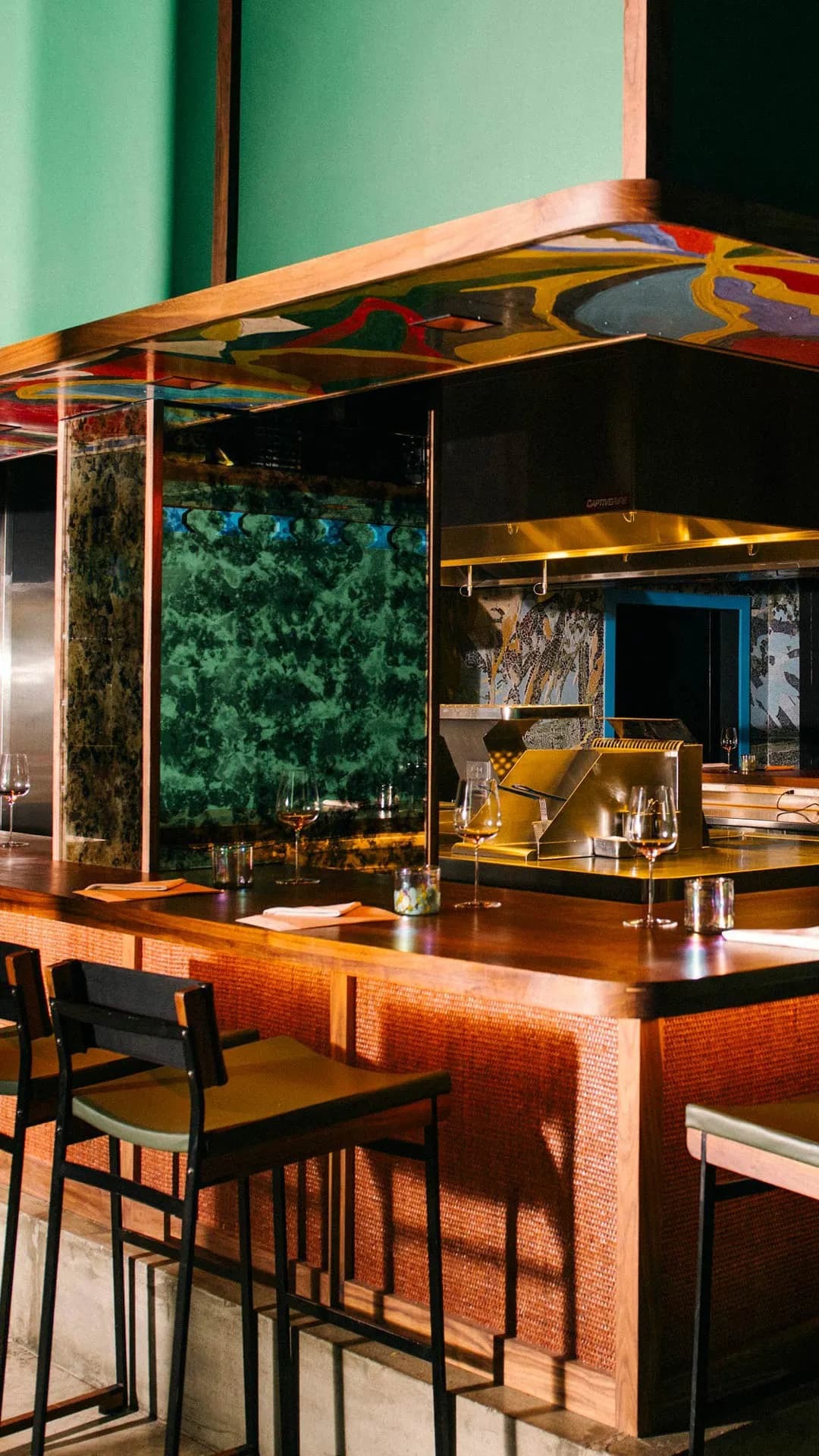 Kabawa dining room interior: open kitchen counter with custom mosaic and bar seating