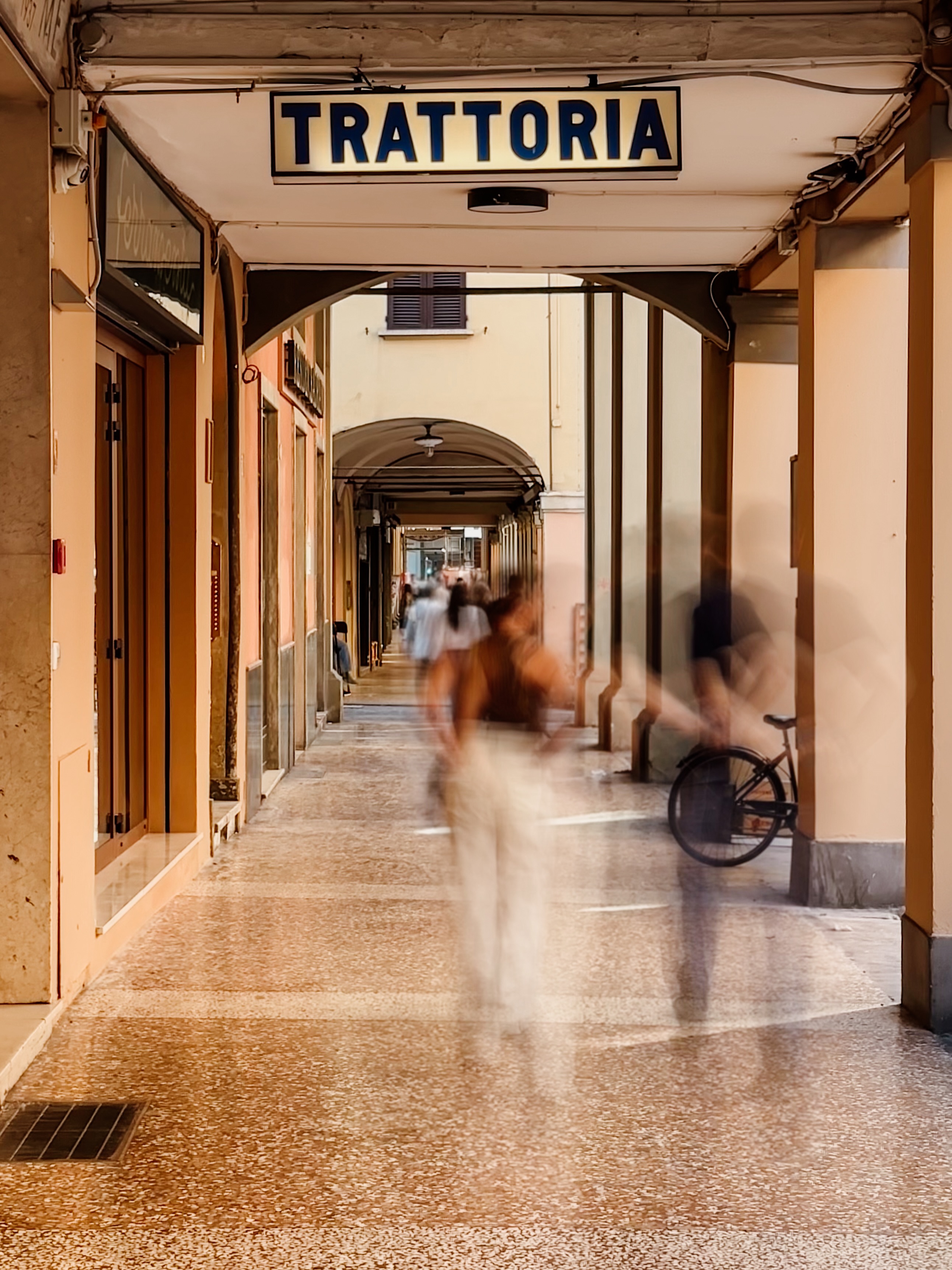 The portico outside Trattoria Da Me on Via San Felice in Bologna — the trattoria sign under the city's covered walkways