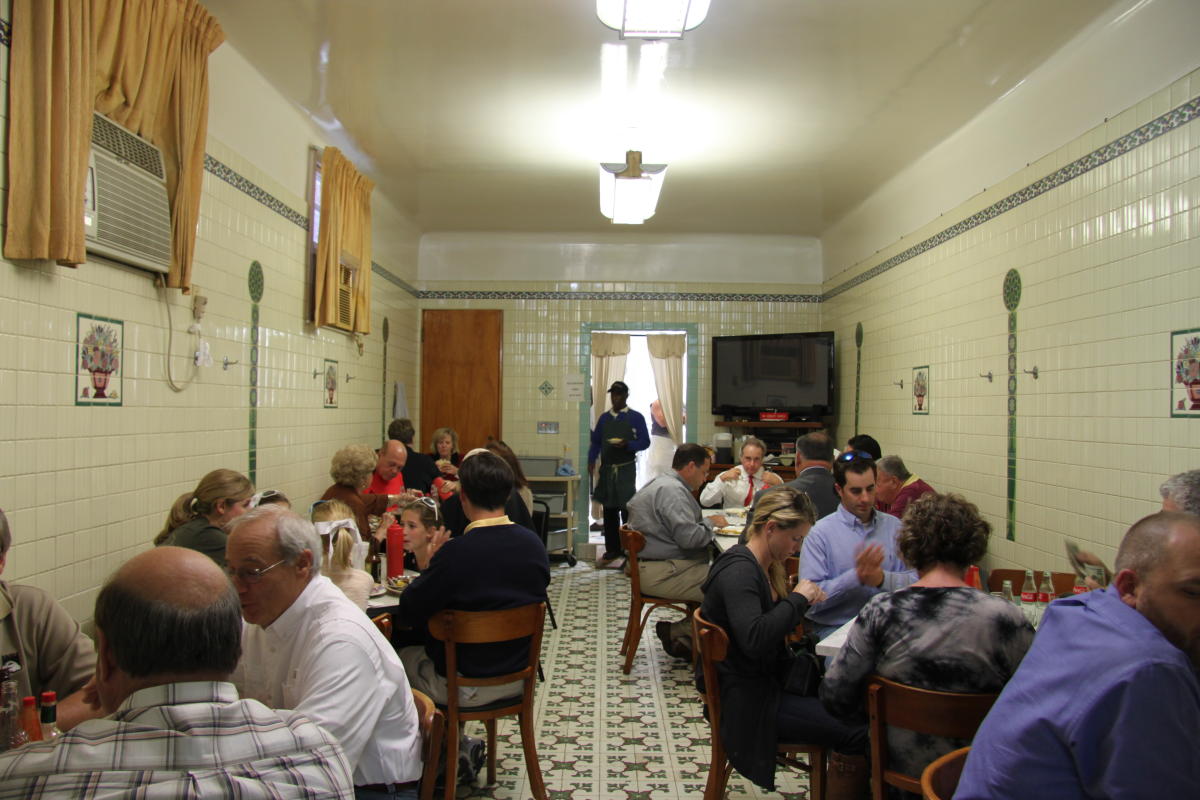 The tile-clad dining room at Casamento's, packed with diners under fluorescent light.