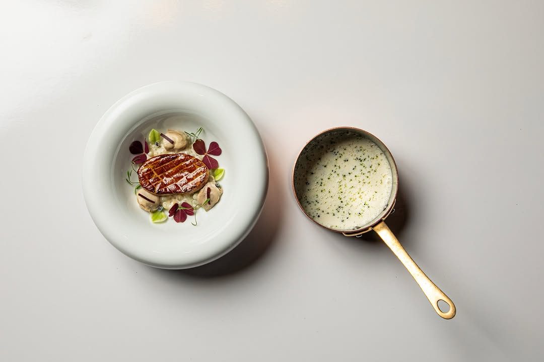Emeril's oyster stew with Herbsaint cream, seared foie gras, and honshimeji mushrooms.