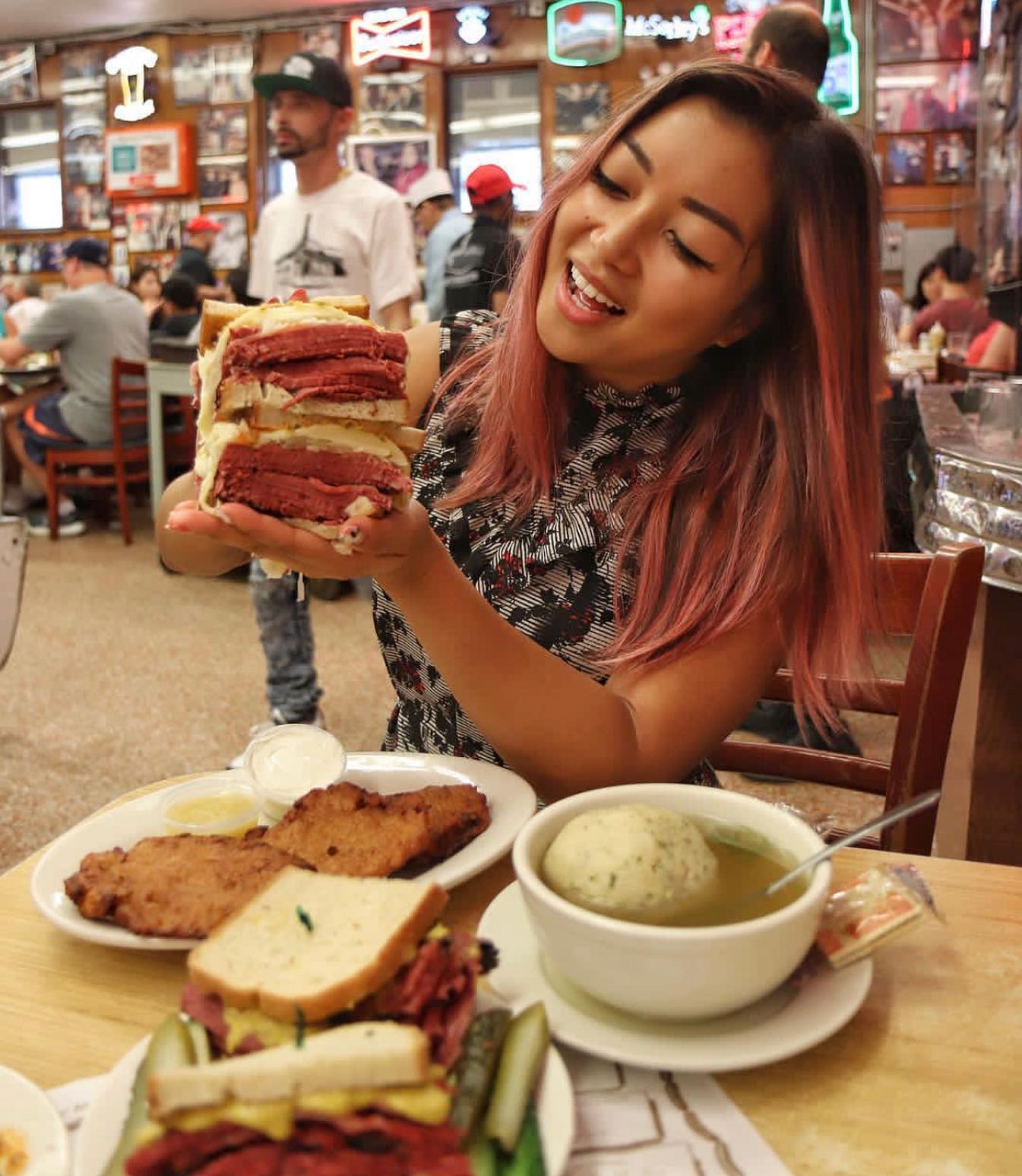 The old-school dining room at Katz's Delicatessen — neon signs, framed photos, crowded tables