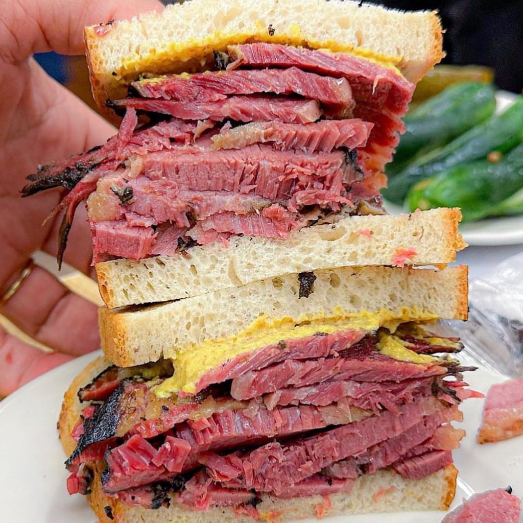 Hand-carved pastrami on rye at Katz's Delicatessen — pepper-crusted slices stacked thick