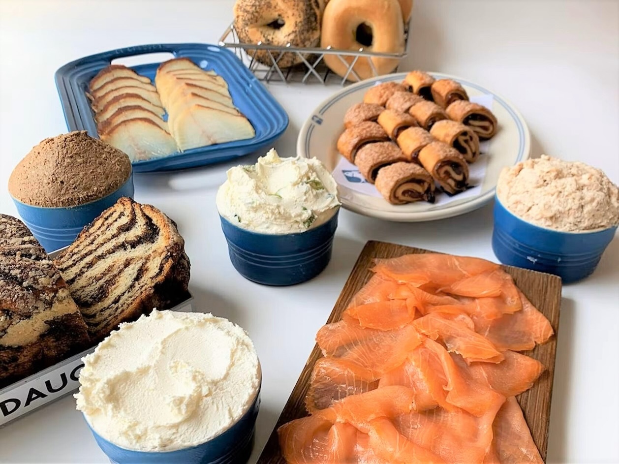 The Russ & Daughters spread on East Houston Street — sliced lox fanned on a wooden board with bagels, cream cheese, whitefish salad, and babka.