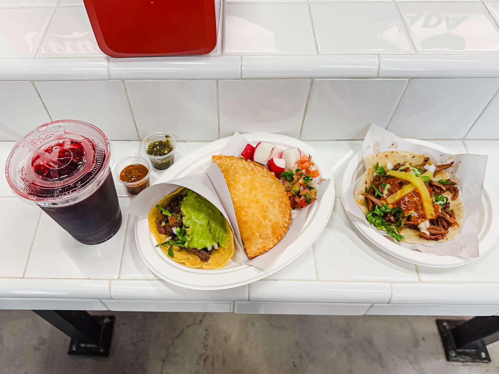 The spread at Los Tacos No.1: carne asada, adobada, and a jamaica agua fresca.
