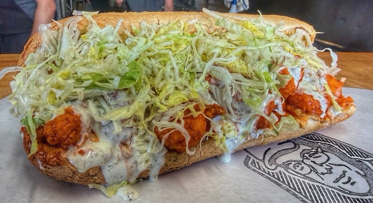 The Saucy Boy po'boy at Pop's Poboys: crispy Gulf shrimp with remoulade, ranch, and buffalo sauce under shredded lettuce.